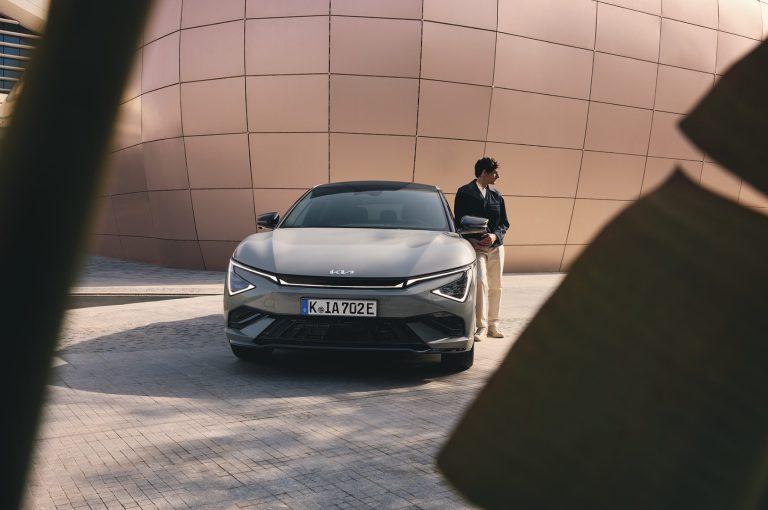 EV6_GTL_MY25_LifstyleExterior_FullFront_with_Talent_CMYK